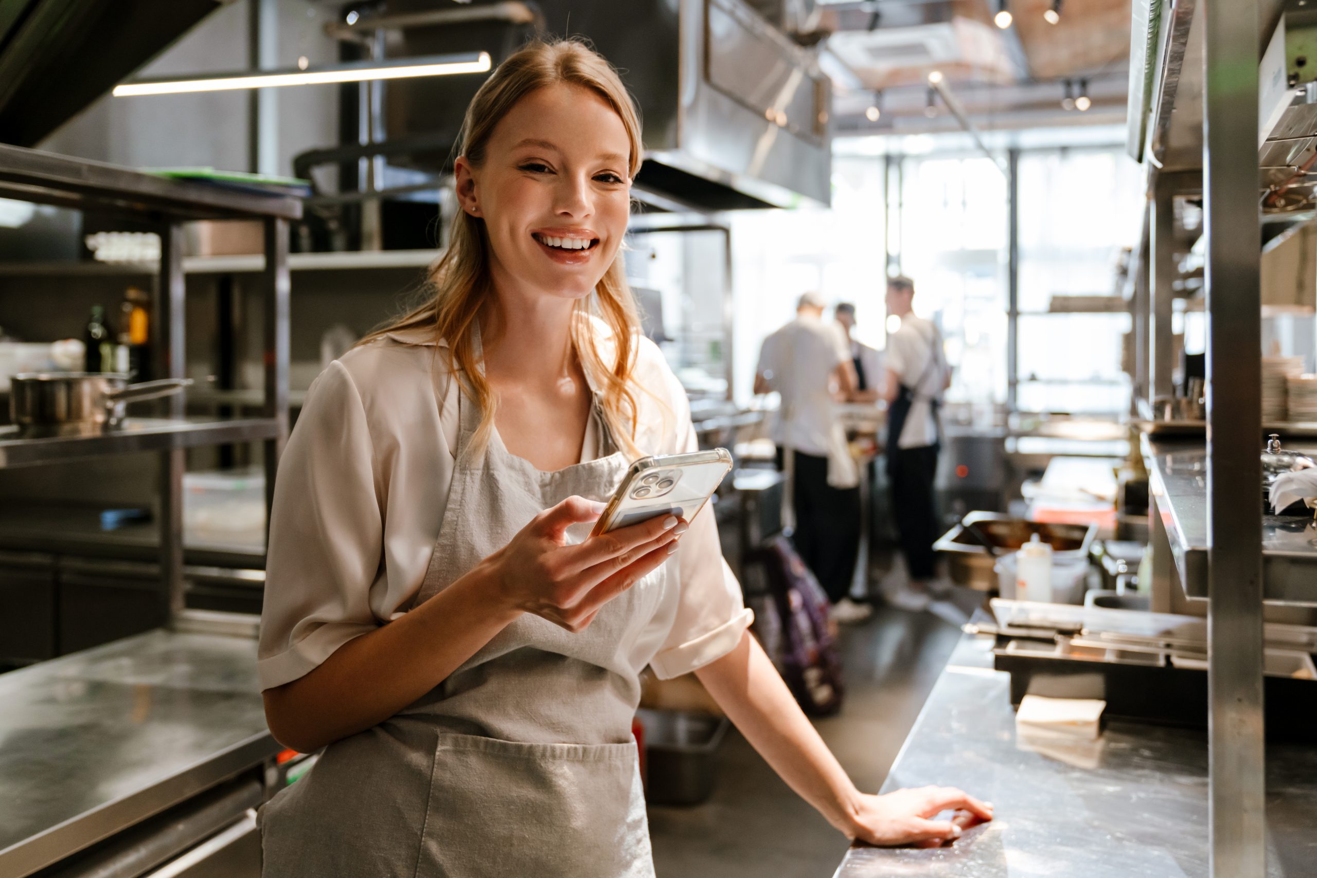 Gastronomie-Mitarbeiterin mit Smartphone